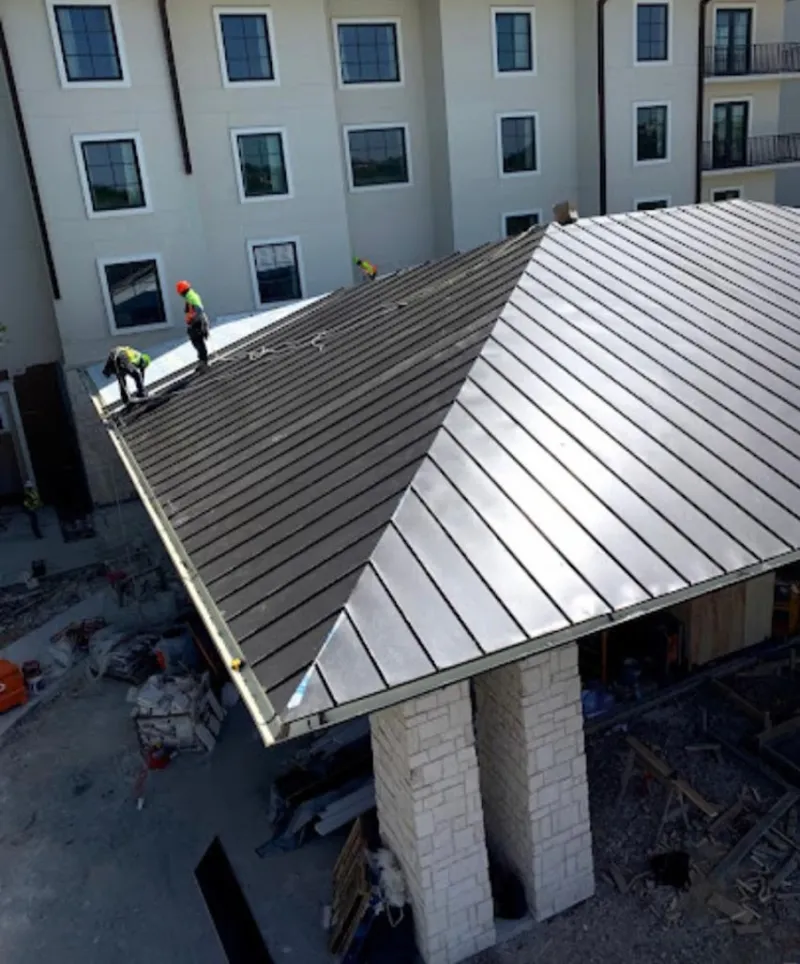 Crew installing standing seam metal roof panels on a commercial project in Butte-Silver Bow